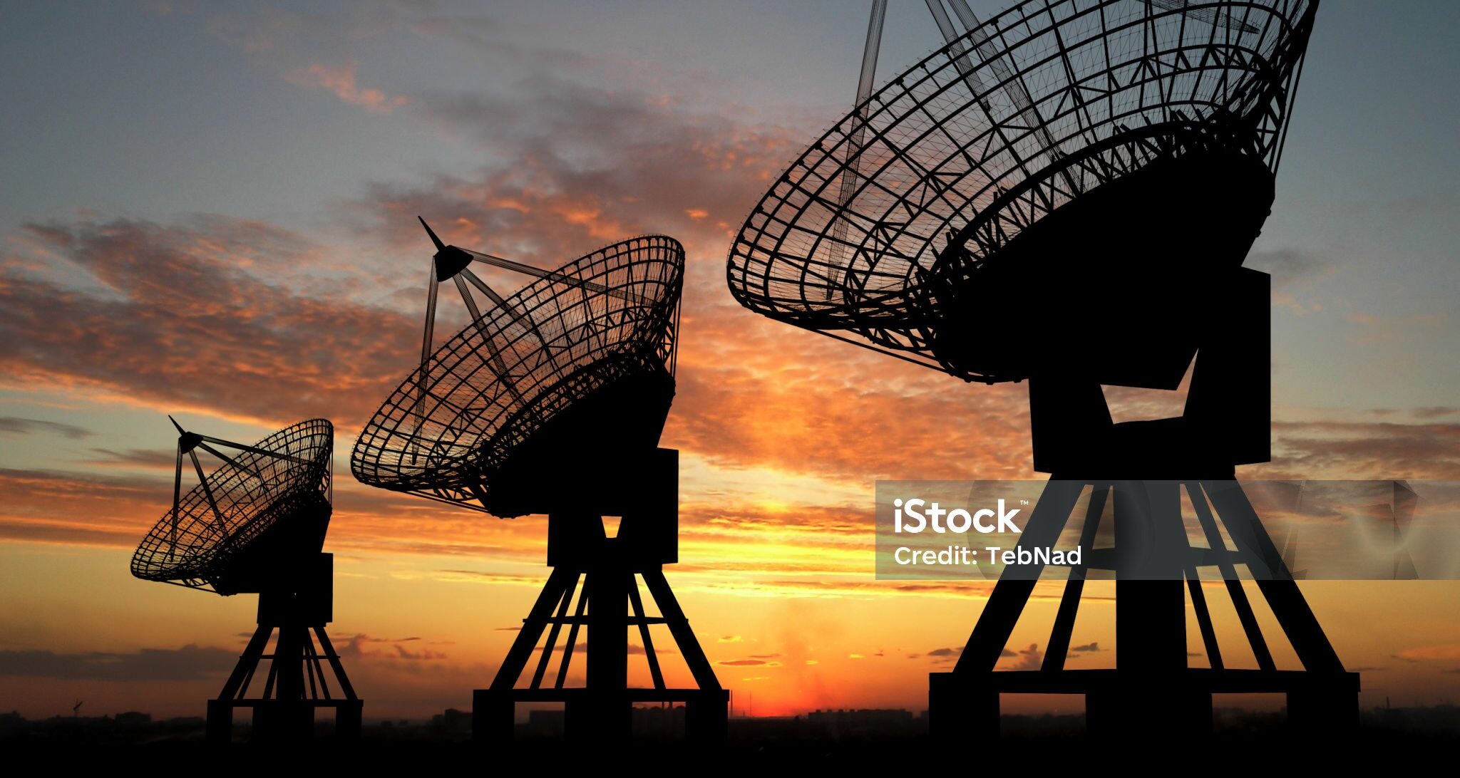 Three satelite dishes over sunset